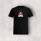 Black t-shirt with a shark graphic on a textured gray background