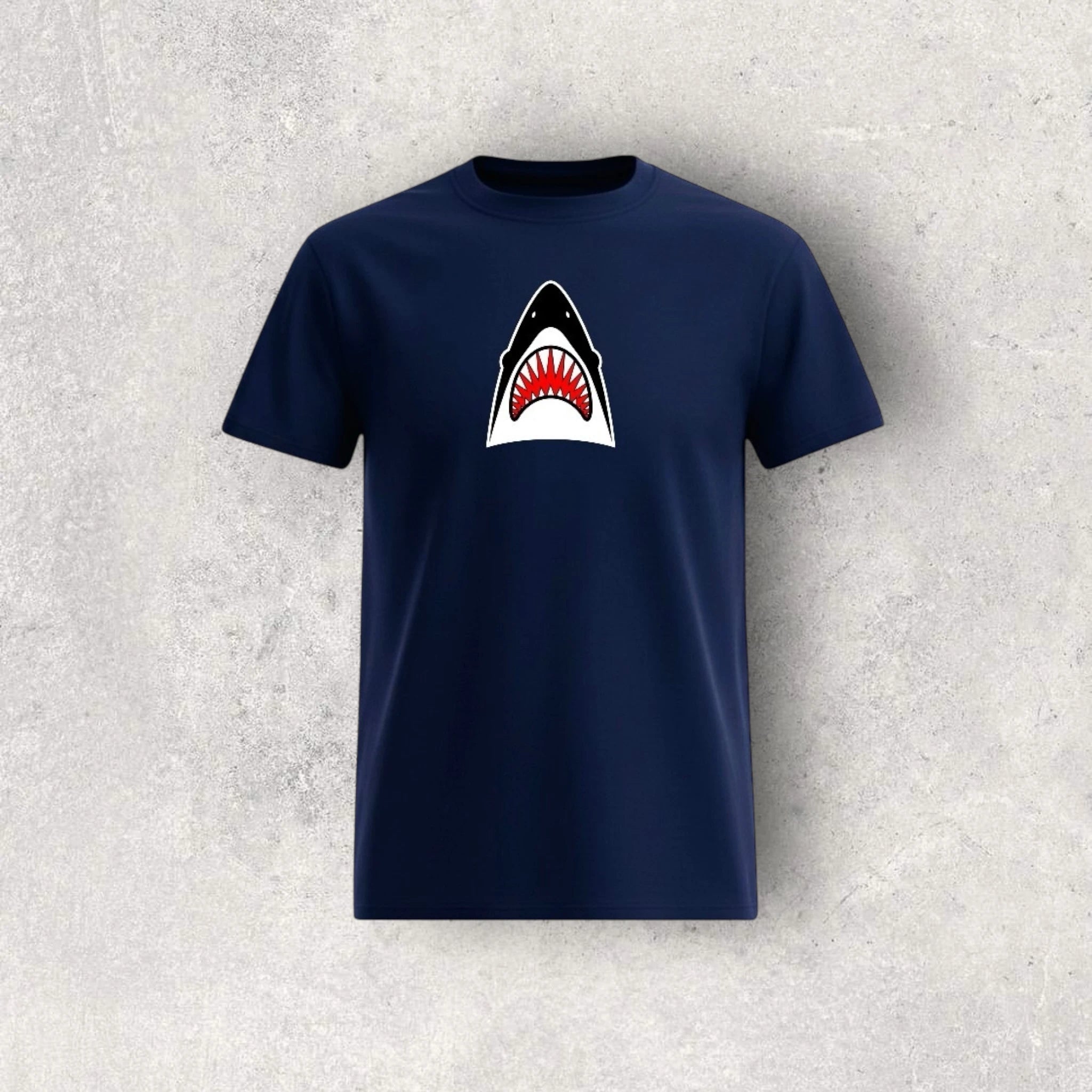 Navy blue t-shirt with a shark graphic on a textured gray background