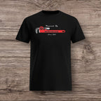 Black t-shirt with a plumber wrench design on a wooden surface