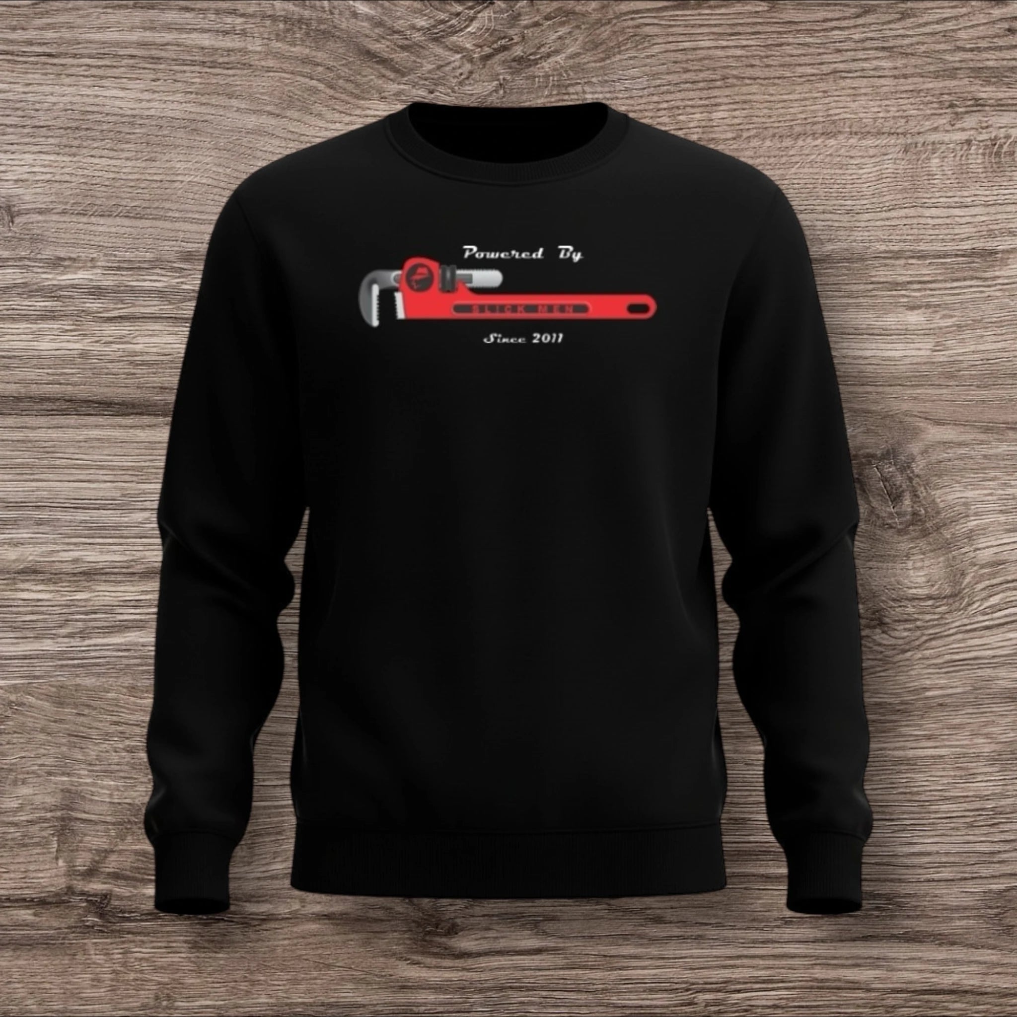 Black sweatshirt with a plumber wrench on a wooden surface