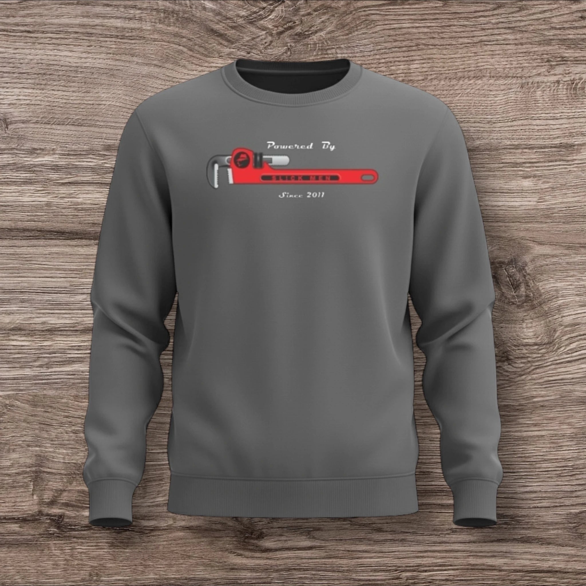 Gray sweatshirt with a plumber wrench on a wooden surface