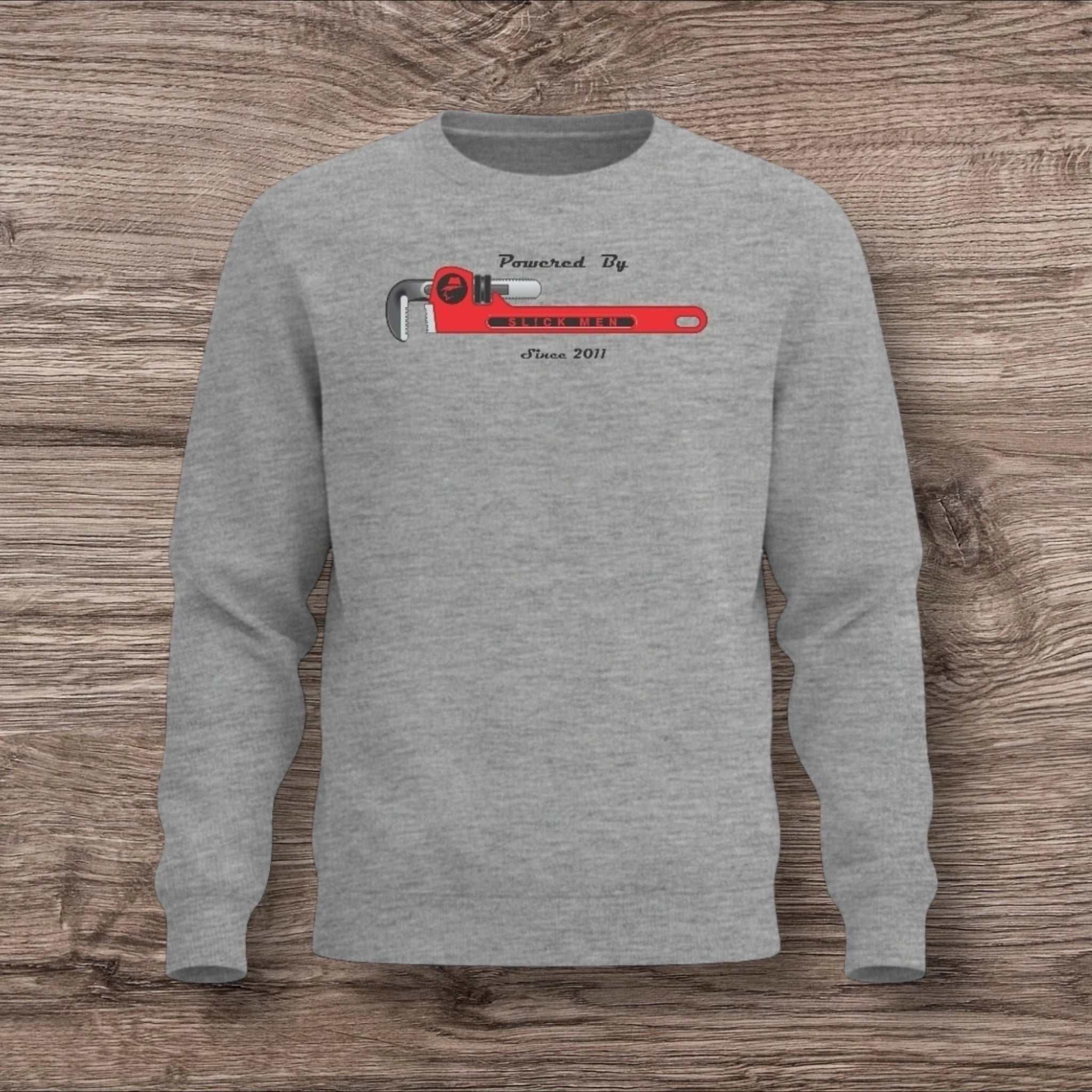 Sport Gray sweatshirt with a plumber wrench graphic on a wooden surface