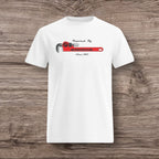 White t-shirt with a plumber wrench design on a wooden surface