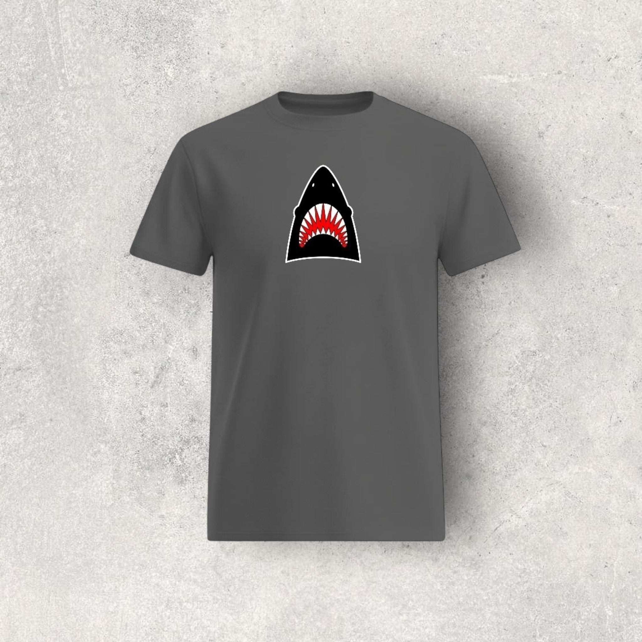 Gray t-shirt with a shark graphic on a textured gray background