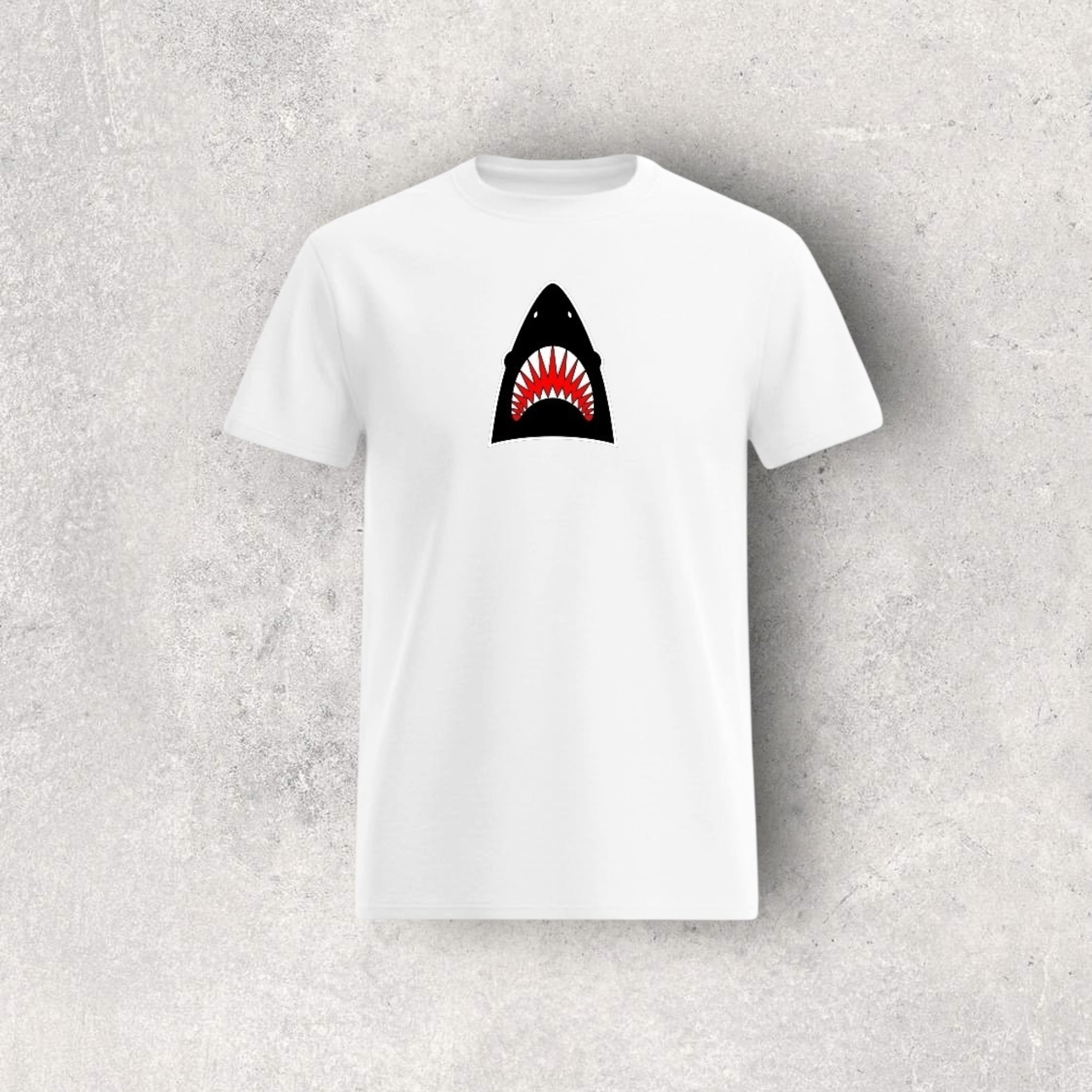 White t-shirt with a shark graphic on a gray textured background
