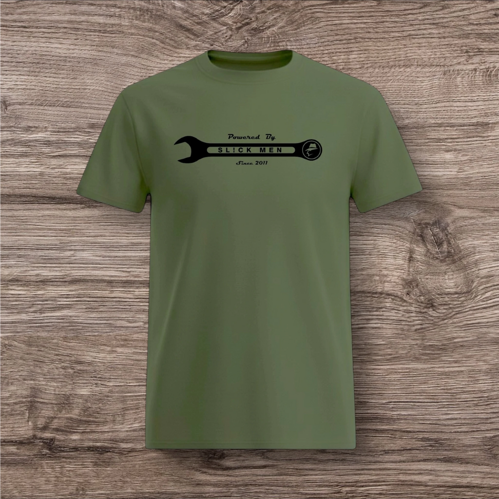 Green t-shirt with a black wrench graphic on a wooden surface