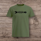 Green t-shirt with a black wrench graphic on a wooden surface