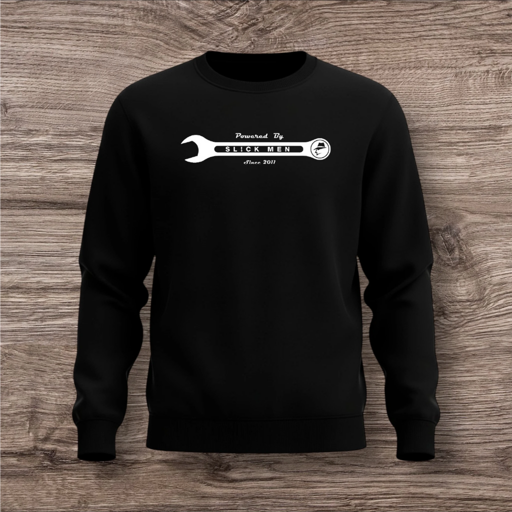 Black sweatshirt with a white wrench graphic on a wooden surface