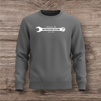 Gray sweatshirt with a white wrench graphic on a wooden surface