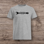 Gray t-shirt with a black wrench graphic  on a wooden surface