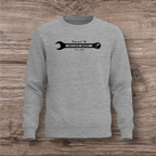 Gray sweatshirt with a black wrench graphic on a wooden surface